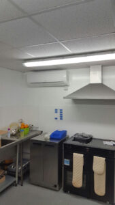 A white wall mounted AC unit installed by PRA for a commercial kitchen