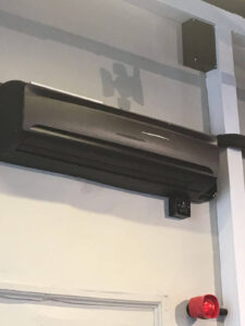 A sleek black AC unit installed against a white wall