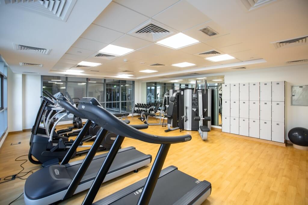 Gym with treadmills and vented ceiling AC