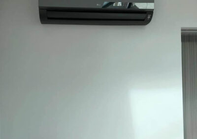 Black LG air conditioning unit installed on a wall by PRA Air Conditioning Engineers